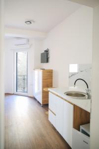 a white kitchen with a sink and a wooden floor at Apartments Murdzoski in Struga