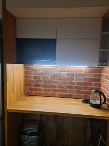 ein Holzregal mit Ziegelwand dahinter in der Unterkunft Apartament 3 pokoje in Słupsk + 2 Fotos