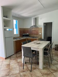 eine Küche mit einem Tisch und Stühlen im Zimmer in der Unterkunft A due passi dal mare in Granitola