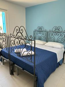 Schlafzimmer mit einem Bett mit blauer und weißer Bettwäsche in der Unterkunft A due passi dal mare in Granitola