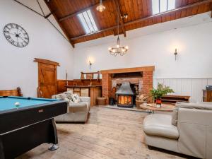 a living room with a pool table and a fireplace at 4 bed property in Isle of Bute 85215 in Kilchattan