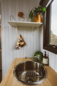 encimera de cocina con fregadero y ventana en River Ridge Tiny House, en South Arm
