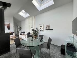 a living room with a glass table and chairs at Wohnung mit grossartiger Seesicht und Balkon in Spiez