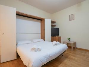 una camera da letto con un letto e due asciugamani di I Host Apartment - Abeti 15 a Baggio