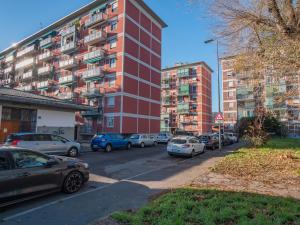 un estacionamiento con autos estacionados frente a un edificio en I Host Apartment - Abeti 15 en Baggio