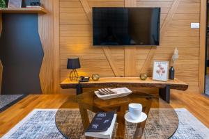 ein Wohnzimmer mit einem Couchtisch und einem TV in der Unterkunft Luxury Mountain Getaway MM2 in Kolašin