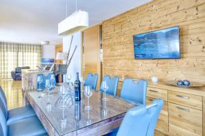 a dining room with a table and blue chairs at Alpin & Seeresort Penthouse 18 - by Alpen Apartments in Zell am See
