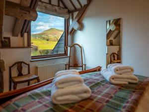 1 dormitorio con toallas en una cama con ventana en 2 bed in Brecon 80519, en Llangorse