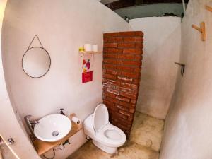 a small bathroom with a toilet and a sink at Maka Hostel in Oaxaca City