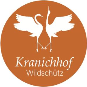 two white birds in a circle with the words kamchatka wildlife rehabilitation at Erholen im Kranichhof, Garten, Sauna - Nähe Heide in Mockrehna