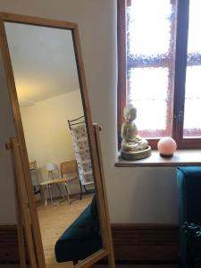 a mirror in a room next to a window at Erholen im Kranichhof, Garten, Sauna - Nähe Heide in Mockrehna