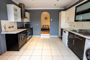 a kitchen with blue walls and white appliances at Fernbanks in Ferndown