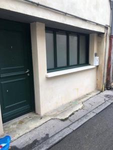 een gebouw met twee groene deuren aan de zijkant bij Suite Glamour & Spa in Dijon