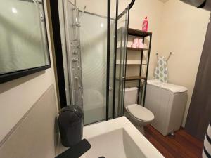 a bathroom with a shower and a toilet and a sink at Maison esprit loft 