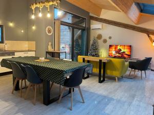 a kitchen and dining room with a table and chairs at Maison esprit loft in Courbesseaux