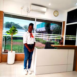 a woman wearing a bow tie standing next to a counter at SPIRIT OF INDIA in Lagos