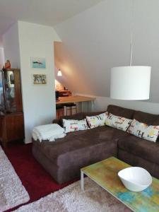 uma sala de estar com um sofá castanho e uma mesa em Ferienwohnung Hude em Hude
