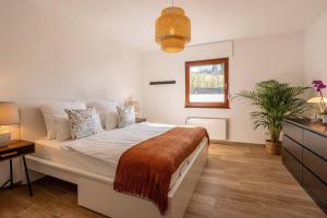 a bedroom with a large white bed and a window at Nature Retreat Pool, Hot Tub, Sauna, Hiking-Caves in Hohenfels-Essingen