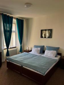 a bedroom with a large bed with blue sheets at Stará pošta in Telnice