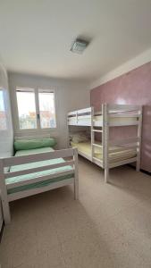 a room with two bunk beds and two windows at Villa dans son jus avec grande piscine privée in Saint-Aygulf