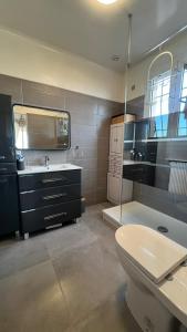 a bathroom with a toilet and a sink and a tub at Villa dans son jus avec grande piscine privée in Saint-Aygulf