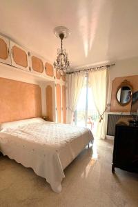 a bedroom with a large bed and a chandelier at Villa dans son jus avec grande piscine privée in Saint-Aygulf
