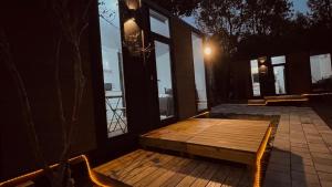 a wooden bench sitting on a porch with windows at Gandan Inn2 in Douliu