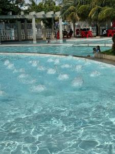 a pool of blue water with people in it at Lacqua diRoma com cozinha e park 24h in Caldas Novas