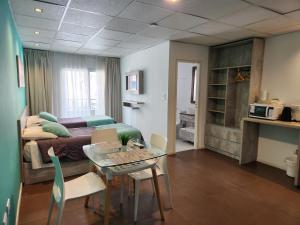 a living room with a bed and a table and a bedroom at PH suites in Río Cuarto