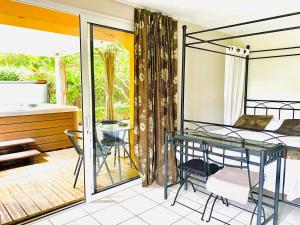 - une chambre avec un balcon doté d'un lit et d'une table dans l'établissement Maison D'hôtes Lagatine, à La Boissière-École