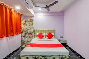 - une chambre avec un lit et des oreillers rouges dans l'établissement OYO Flagship Kirtiraj Lodging and Boarding, à Mumbai