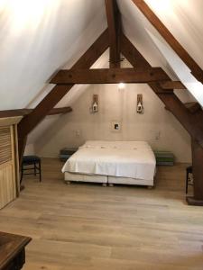 a bedroom with a white bed in a attic at Domaine de la Haute Justerie - piscine & billard à l’orée des bois - Loire Valley in Fondettes