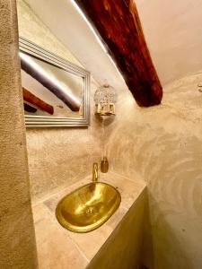 lavabo de oro en un baño con ventana en La Pequeña Cantonesa, en Olba