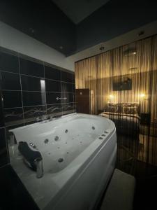 a bathroom with a large white bath tub at Pensiunea Old Sheriff in Bistriţa