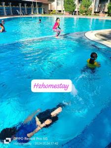 a group of children playing in a swimming pool at Ocean view resort homestay near beach free wifi,cucckoo 3ROOM in Port Dickson