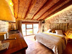 a bedroom with a bed and a stone wall at La Pequeña Cantonesa in Olba