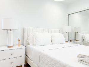 a white bedroom with a large bed and two lamps at 1 BR exceptional house PCHL-TOP in Topanga