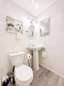 a white bathroom with a toilet and a sink at 1 BR exceptional house PCHL-TOP in Topanga