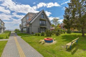 una casa con un patio con un banco delante en SOLEMAR romantic studio with lagoon View!, en Pervalka
