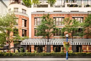 un grand bâtiment en briques avec un auvent en face dans l'établissement The Hazelton Hotel, à Toronto