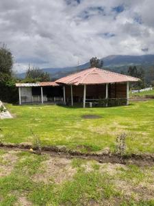 een huis met een tegeldak in een veld bij HOTELERIA CASA MAYA in Riobamba