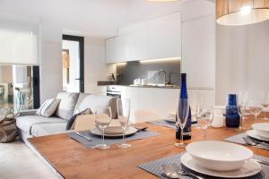 a dining room with a table with plates and wine glasses at YourHouse Iris House in Colonia de Sant Pere