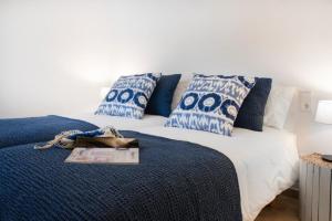 a bedroom with a bed with blue and white pillows at YourHouse Iris House in Colonia de Sant Pere +3 photos