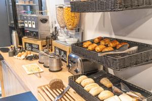 a counter with baskets of donuts and other food at Montempô Appart'Hôtel Bordeaux Centre - Bassins à flot in Bordeaux