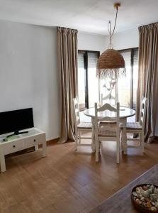 een woonkamer met een witte tafel en een tv bij Sun & Sea Beach Apartment Sabinillas in San Luis de Sabinillas