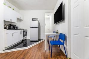 cocina con mesa, 2 sillas y nevera en Modern NY Style 2BD Apartment in Upper East Side Manhattan, en Nueva York