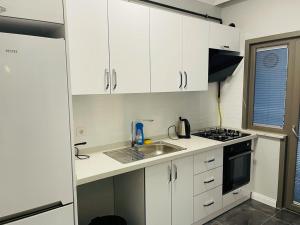 a small kitchen with white cabinets and a sink at Cantrmen Suites in Istanbul