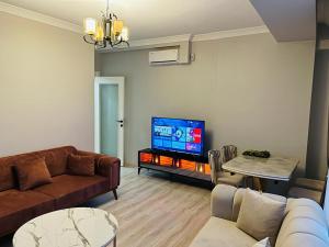 a living room with a couch and a flat screen tv at Cantrmen Suites in Istanbul