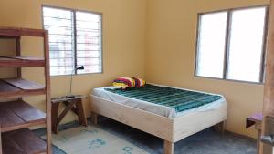 Dario's Room1 في Kokrobite: غرفة نوم صغيرة بها سرير ونوافذ