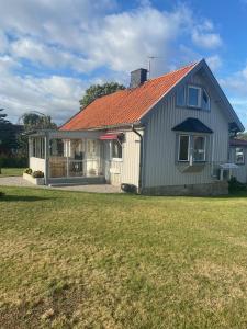 una casa con techo naranja y patio en Cosy cottage located close to a bay in Skappevik, en Bergkvara